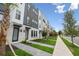 Modern townhouse exterior featuring brick accents, landscaping, and a sidewalk along the street at 2296 Brix Sts, Orlando, FL 32804