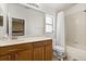 Bright bathroom featuring a wooden vanity with large mirror, shower-tub combo with shower curtain, and a window at 2422 Holly Pine Cir, Orlando, FL 32820