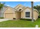 Charming single-story home with a well-maintained lawn, integrated garage, and tasteful neutral color palette at 2422 Holly Pine Cir, Orlando, FL 32820