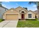 Inviting single-story home with a well-manicured lawn, attached garage, and a vibrant red front door at 2422 Holly Pine Cir, Orlando, FL 32820