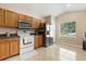 Functional kitchen features wood cabinetry, modern appliances, and easy-to-clean tile flooring for convenience at 2422 Holly Pine Cir, Orlando, FL 32820