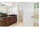 Bright bathroom featuring granite counters, dark wood cabinets, tile flooring, and a separate toilet room at 2588 Gabrielle Woods Pl, Oviedo, FL 32765