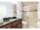 Elegant bathroom with granite counters, wood cabinets, tiled shower, and modern fixtures at 2588 Gabrielle Woods Pl, Oviedo, FL 32765