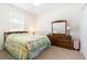 Bedroom with a patterned quilt on the bed, wooden dresser, and carpet flooring under a ceiling fan at 2588 Gabrielle Woods Pl, Oviedo, FL 32765