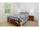 Cozy bedroom with a window view, featuring a quaint bed, side tables, and carpet flooring at 2588 Gabrielle Woods Pl, Oviedo, FL 32765
