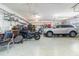 Organized garage space with a motorcycle, a car, ceiling fans, and ample storage shelving at 2588 Gabrielle Woods Pl, Oviedo, FL 32765
