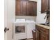 Well-equipped laundry room featuring a sink, granite counters, and dark wood cabinets at 2588 Gabrielle Woods Pl, Oviedo, FL 32765