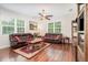 Spacious living room with hardwood floors, comfortable leather sofas, and lots of natural light at 2588 Gabrielle Woods Pl, Oviedo, FL 32765