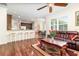 Open-concept living room featuring dark wood floors, an eat-in kitchen, and leather sofas at 2588 Gabrielle Woods Pl, Oviedo, FL 32765