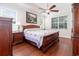 Bright main bedroom with hardwood floors, large bed, and windows with shutter-style blinds at 2588 Gabrielle Woods Pl, Oviedo, FL 32765