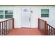 Exterior shot showcasing the front door entrance with a small porch and white siding, providing curb appeal at 2623 8Th St, Orlando, FL 32820