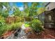Lush backyard featuring garden beds and patio with walkway to a screened-in porch at 2794 Cullens Ct, Ocoee, FL 34761