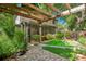 Lush backyard featuring a pergola, fountain, artificial grass, and manicured landscaping at 2794 Cullens Ct, Ocoee, FL 34761