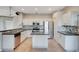 A kitchen features white cabinets, stainless steel appliances, tile flooring, and an island at 2794 Cullens Ct, Ocoee, FL 34761