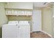Functional laundry room featuring washer, dryer, storage cabinets, and tile flooring at 2794 Cullens Ct, Ocoee, FL 34761