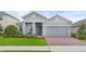 Charming single-story home featuring a well-manicured lawn, two-car garage, and inviting front porch at 2929 Bluestem Ln, Clermont, FL 34714