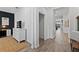 Hallway view from office showing laundry room and an open living area with hardwood floors at 2929 Bluestem Ln, Clermont, FL 34714