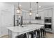 Modern kitchen with a large island, stainless steel appliances, pendant lighting, and grey cabinets at 2929 Bluestem Ln, Clermont, FL 34714
