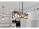 Bright kitchen with a wooden light fixture, stainless steel appliances and gray cabinetry at 2929 Bluestem Ln, Clermont, FL 34714