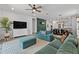 Spacious living room with a modern ceiling fan and plush blue seating arrangement at 2929 Bluestem Ln, Clermont, FL 34714