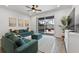 Cozy living room with a comfy green sofa, ceiling fan, and sliding doors to the patio at 2929 Bluestem Ln, Clermont, FL 34714