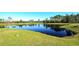 A view of the pond, lined by grassy banks and trees at 2929 Bluestem Ln, Clermont, FL 34714