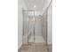 Modern walk-in shower featuring sleek glass doors, tiled walls, and a built-in bench at 2929 Bluestem Ln, Clermont, FL 34714