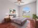 Bright bedroom featuring a large window, comfortable furnishings, and hardwood floors at 3713 Becontree Pl, Oviedo, FL 32765