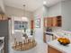 Cozy kitchen nook featuring modern appliances, warm wood cabinets, and a sunlit dining area at 3713 Becontree Pl, Oviedo, FL 32765