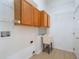 Laundry room with overhead cabinets, a utility sink, and tiled floors at 3713 Becontree Pl, Oviedo, FL 32765