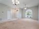 Bright living room with a large window, neutral carpet, and elegant light fixtures at 3713 Becontree Pl, Oviedo, FL 32765