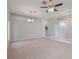 Open-concept living room with neutral carpet and modern ceiling fan and light fixtures at 3713 Becontree Pl, Oviedo, FL 32765