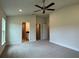 Large primary bedroom with carpet, fan, and doorway to primary bathroom at 3891 Sagefield Dr, Harmony, FL 34773