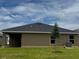 The exterior view of home shows a covered patio and well-maintained lawn with healthy green grass at 3891 Sagefield Dr, Harmony, FL 34773