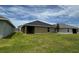 The exterior view shows the side of the house and the covered patio with the healthy green grass at 3891 Sagefield Dr, Harmony, FL 34773