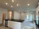 Open-concept living space with a kitchen island, stainless steel appliances, and ample natural light at 3891 Sagefield Dr, Harmony, FL 34773