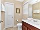 Neutral bathroom with a sink, toilet, white door, a framed art piece, and a window for functionality and style at 4123 Oaktree Dr, Davenport, FL 33837