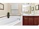 Bright bathroom showcasing a soaking tub and a vanity with generous counter space at 4123 Oaktree Dr, Davenport, FL 33837