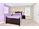 Inviting bedroom with purple accent wall, carpeting, and matching bedside lamps at 4123 Oaktree Dr, Davenport, FL 33837