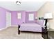Bedroom with purple accent wall, bedside lamps, carpeting, and window light at 4123 Oaktree Dr, Davenport, FL 33837