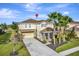 Inviting home boasts a manicured lawn, mature palm trees and neutral color scheme at 4123 Oaktree Dr, Davenport, FL 33837