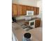 Functional kitchen featuring upper wooden cabinets, a smooth-top stove, and laminate countertops at 4529 Alberto Cir, Kissimmee, FL 34746