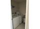 Laundry room equipped with a white washer and dryer, wire shelf, and a rolling laundry cart at 4529 Alberto Cir, Kissimmee, FL 34746