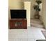 Television cabinet, staircase, and a plant on a landing, all accented by neutral-toned tile flooring at 4529 Alberto Cir, Kissimmee, FL 34746