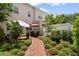 Beautifully landscaped backyard with a brick path leading to a cozy patio and seating area at 4709 Fox St, Orlando, FL 32814