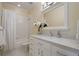 Bright bathroom with marble countertops, white cabinets, shower over tub, and white tile floors at 4709 Fox St, Orlando, FL 32814