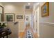 Hallway with hardwood floors, neutral walls, and multiple framed pictures hung, leading to various rooms at 4709 Fox St, Orlando, FL 32814