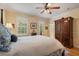 Bedroom featuring a four-poster bed, hardwood floors, and natural light from shuttered windows at 4709 Fox St, Orlando, FL 32814