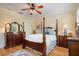 Spacious bedroom featuring a four-poster bed, hardwood floors, and a ceiling fan for comfort at 4709 Fox St, Orlando, FL 32814