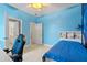 Bright bedroom with blue walls, white trim, a ceiling fan, and an attached bathroom at 5306 Crane Hill Ct, St Cloud, FL 34771